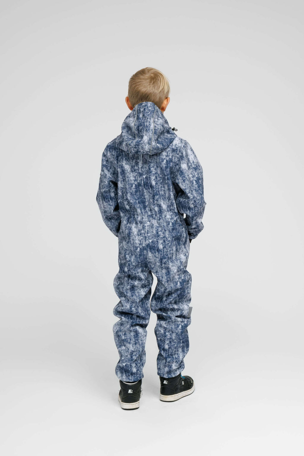 Back view of a child wearing a Softshell Onesie for Kids in a stylish blue design.