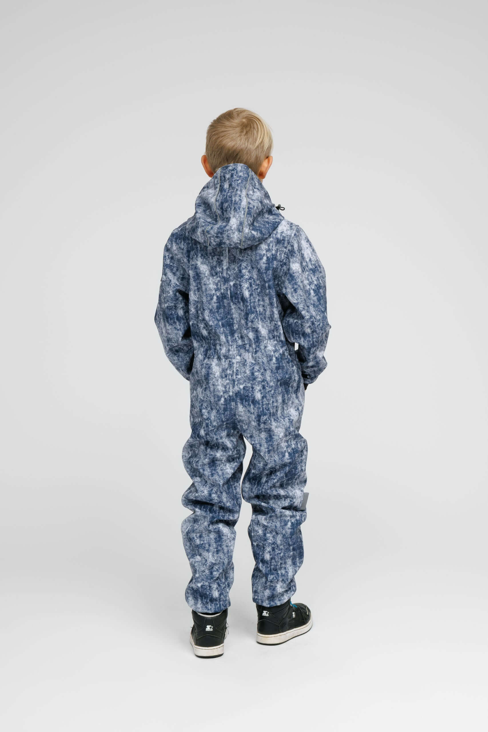 Back view of a child wearing a Softshell Onesie for Kids in a stylish blue design.