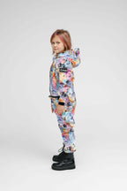 Colorful side view of a child wearing a weather-resistant kids onesie with a hood and zippered pockets.