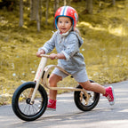 Child riding leg&go Balance Bike in a forest setting, showcasing balance and fun on a wooden bike.