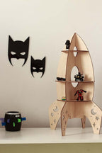 Rocket shelf space decor featuring a wooden rocket-shaped shelf with toys and batman-themed wall decorations.