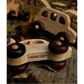Wooden bus by Wooden Story among other wooden toy cars on a natural surface.
