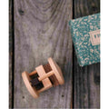 Fieldfare wooden rattle for fine motor skills on wood background with decorative box.