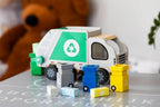 Wooden garbage truck toy with recycling logo and colorful blocks for imaginative play.