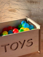 Montessori wooden toy box filled with colorful balls, perfect for organizing toys in a nursery or playroom.