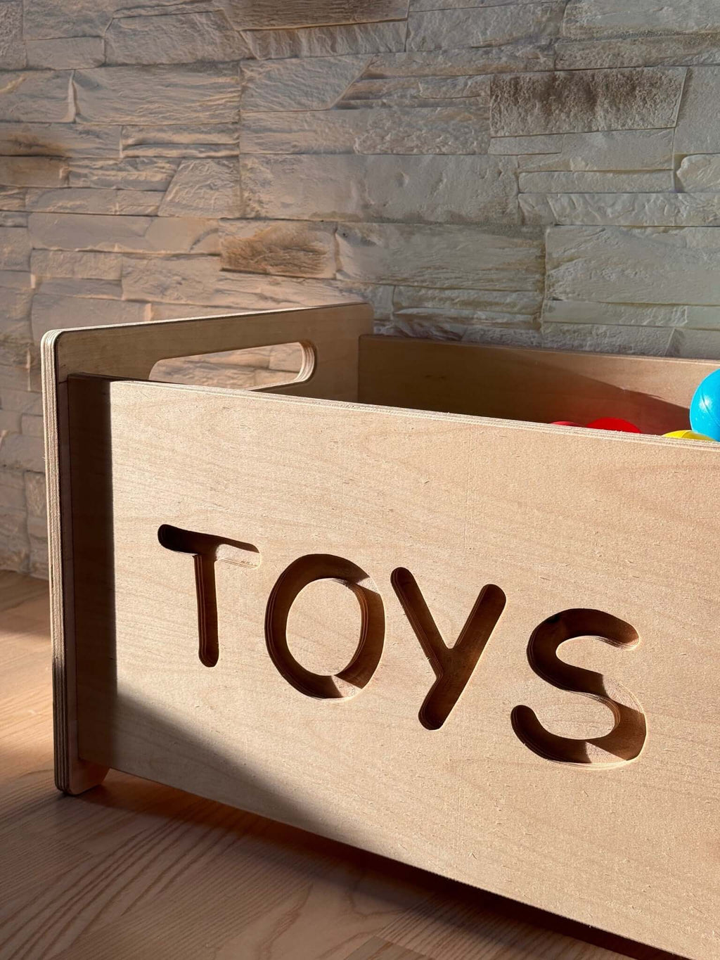 Montessori wooden toy box with cut-out 'TOYS' label, perfect for stylish nursery storage.