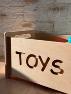 Montessori wooden toy box with cut-out 'TOYS' label, perfect for stylish nursery storage.